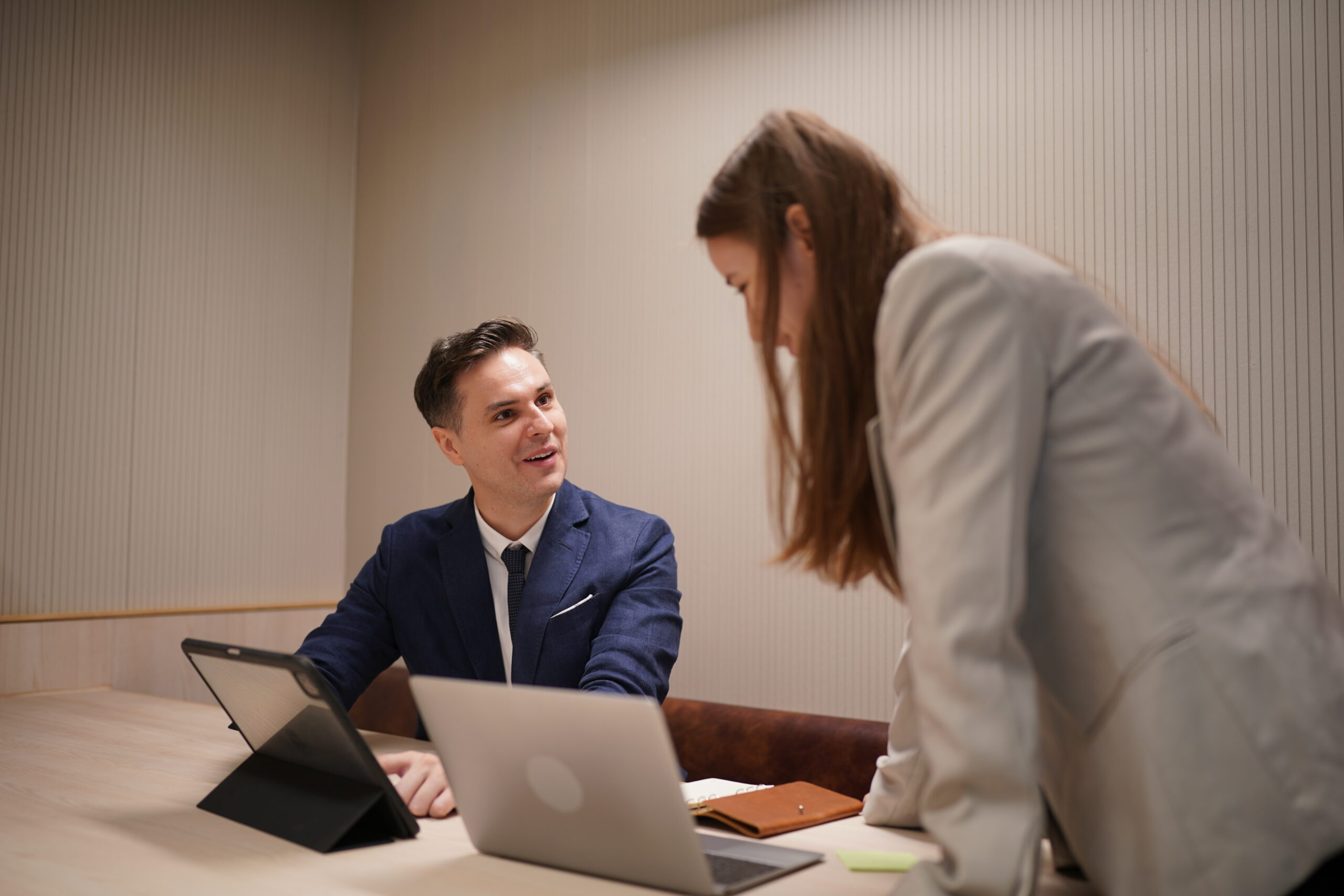 image of young businessmen and colleague discussing document in laptop and touchpad at meeting